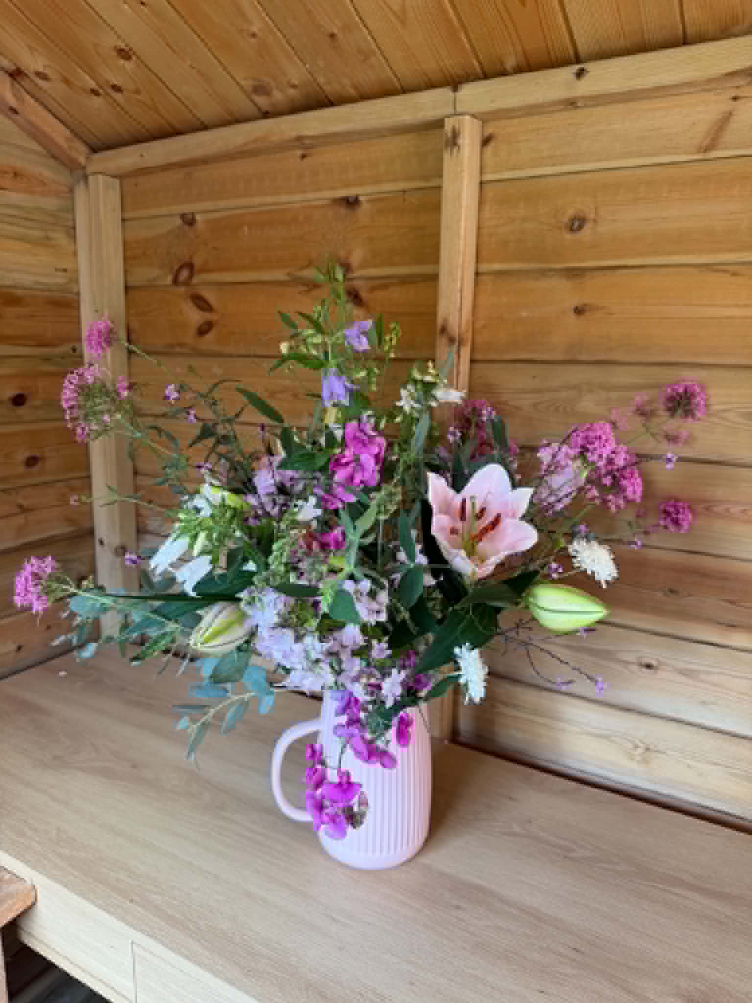 Lily and sweet pea bouquet in a jug