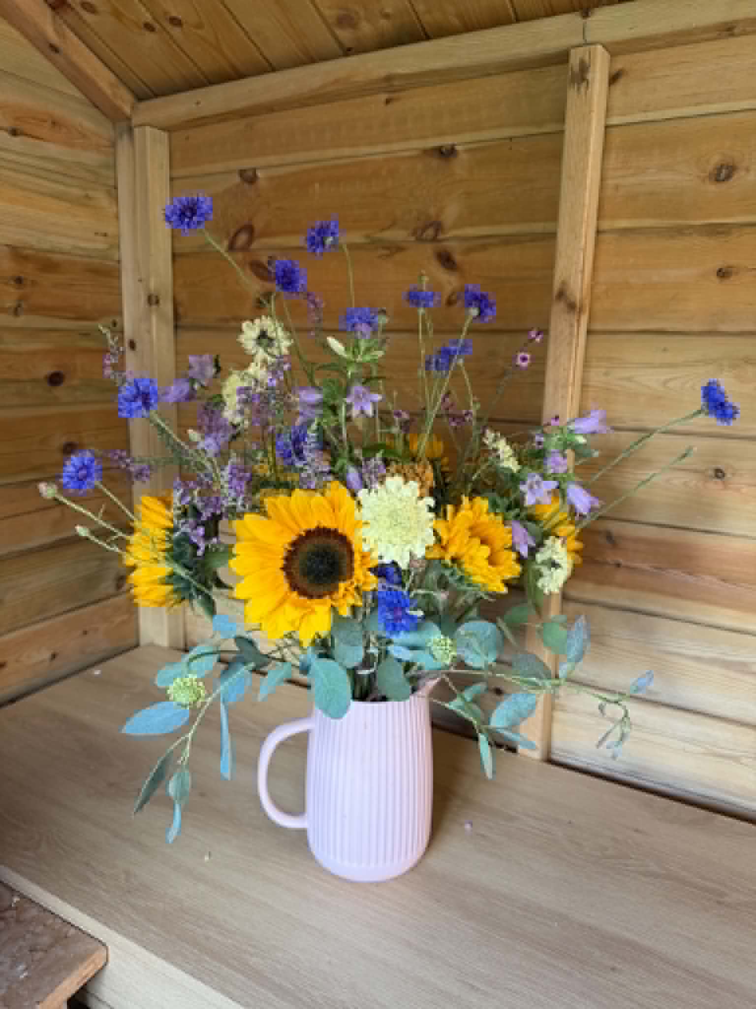 Sunflower and cornflower bouquet in a pink jug