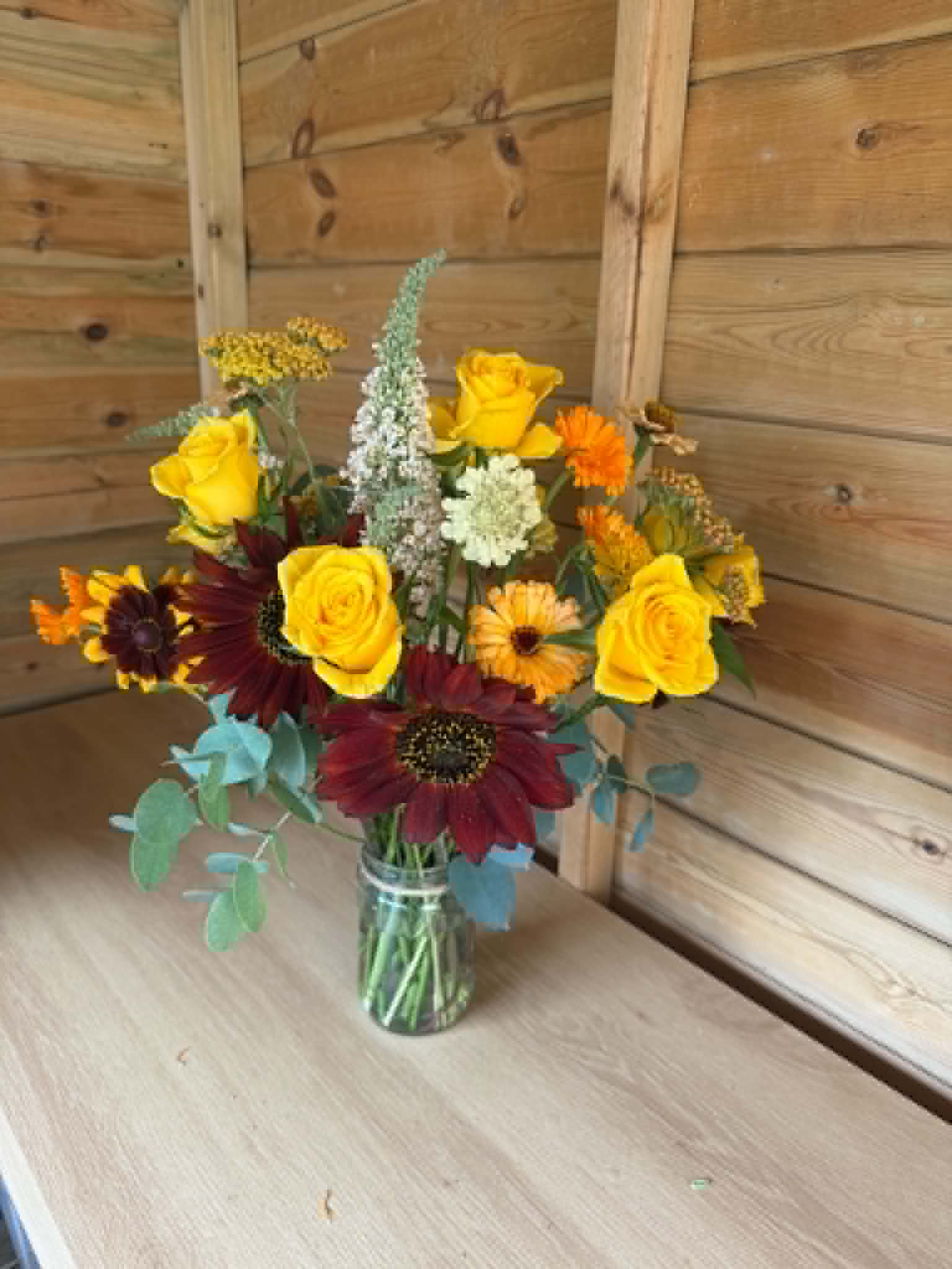 Yellow rose and burgundy bouquet in a jar