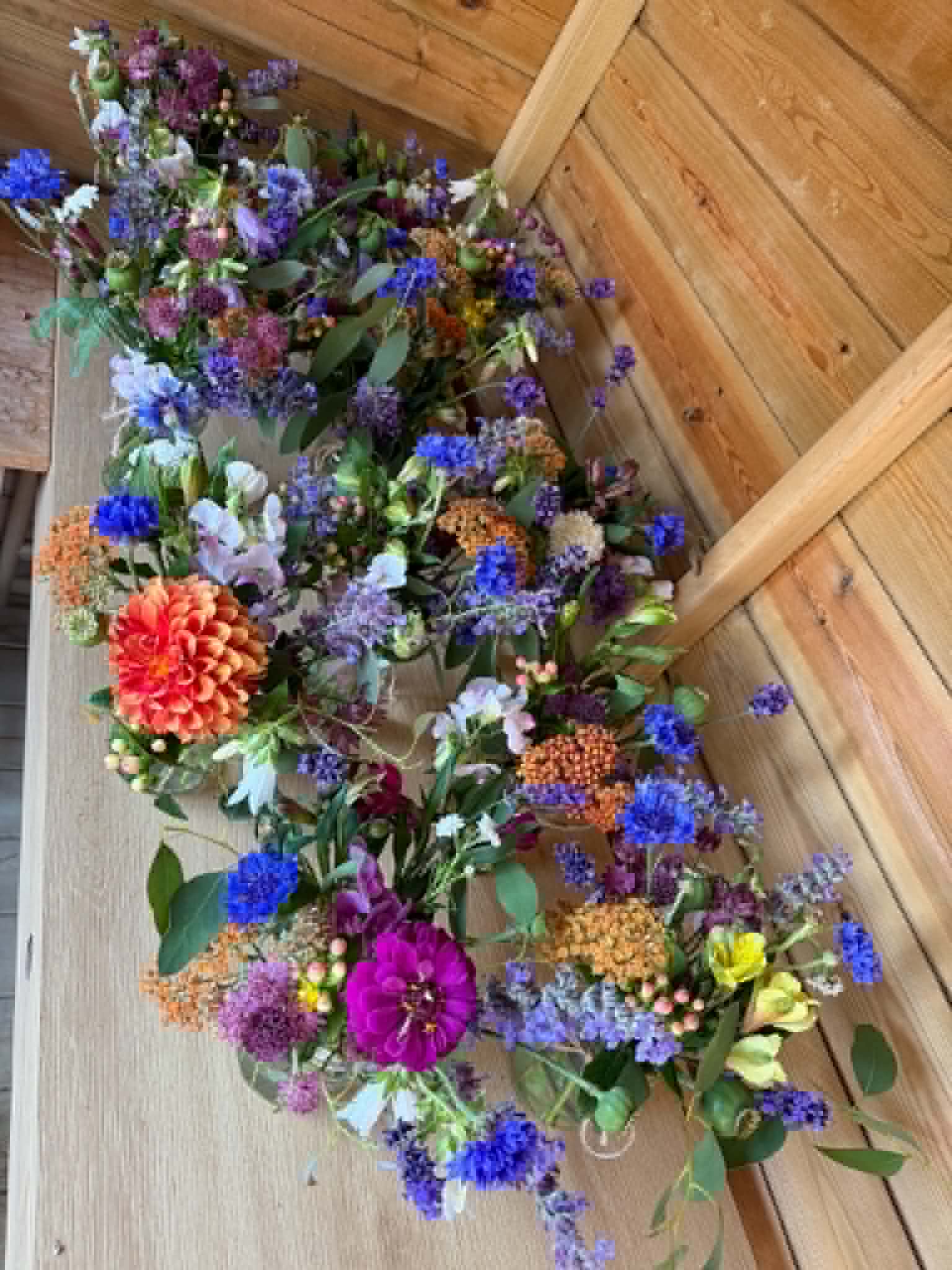 Row of hand-tied posies laid out overhead in the shed